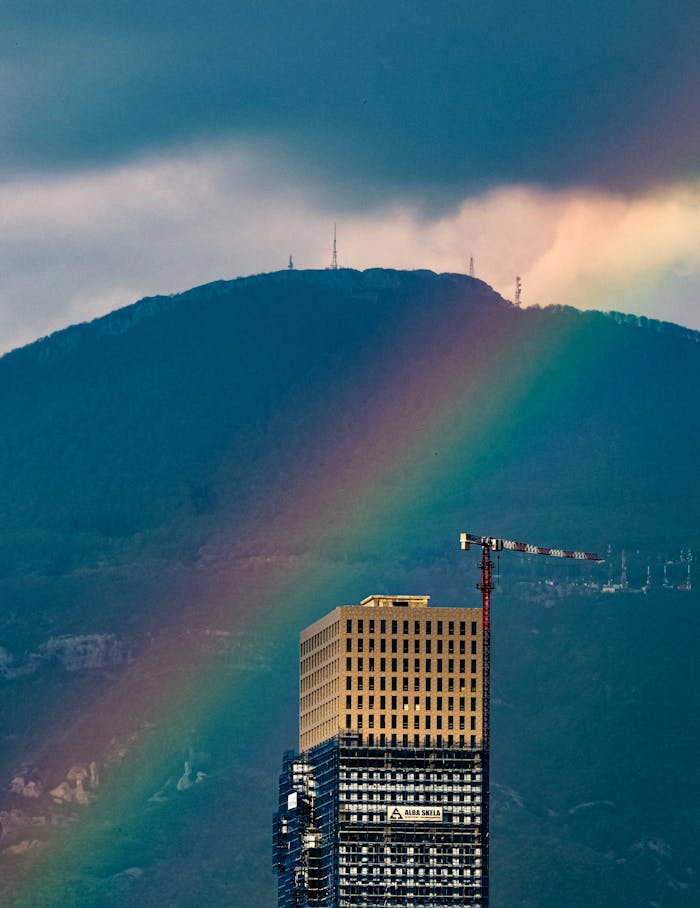 A striking high-rise against a vibrant rainbow backdrop in Tirana, Albania.